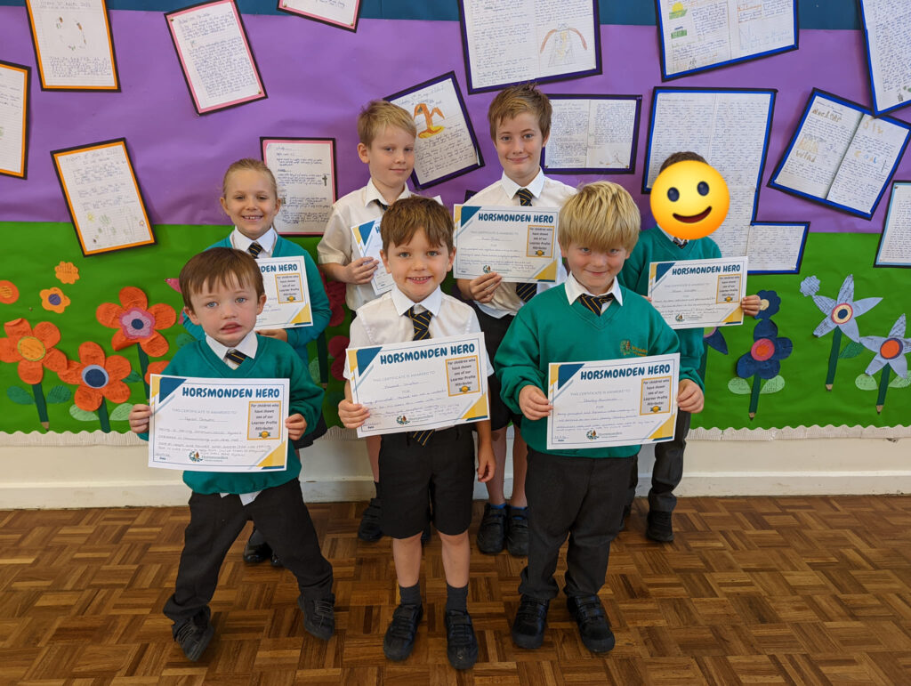 Photo showing winners of the Horsmonden Hero award holding up their certificates and smiling for the camera.