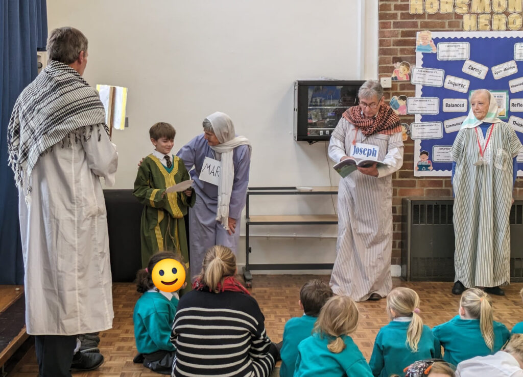 Visitors from the 'Open the Book' Team are pictured delivering a performance of the story 'Where's Jesus?' to a large group of pupils gathered in the school hall.