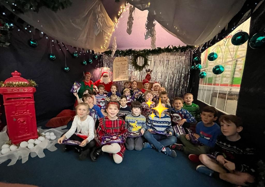 A group of Horsmonden pupils are pictured posing for the camera inside Santa's Grotto, alongside the man himself.