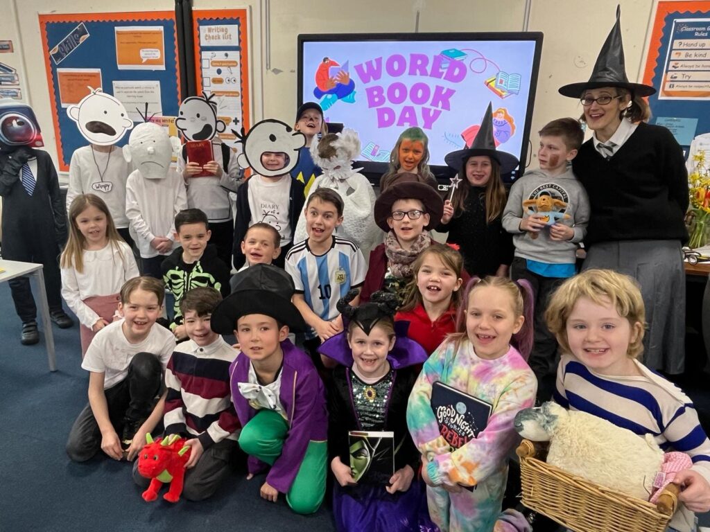 A large group of students are pictured dressed up as well-known characters from books for World Book Day 2024 and smiling for the camera.