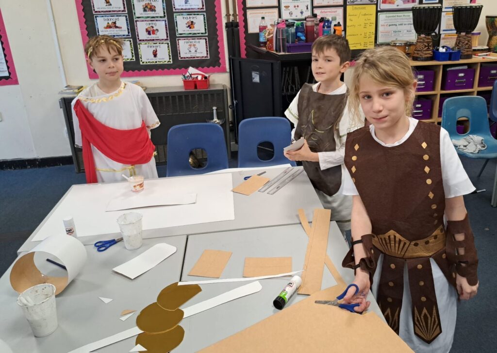 Students smiling for a photo dressed as Romans