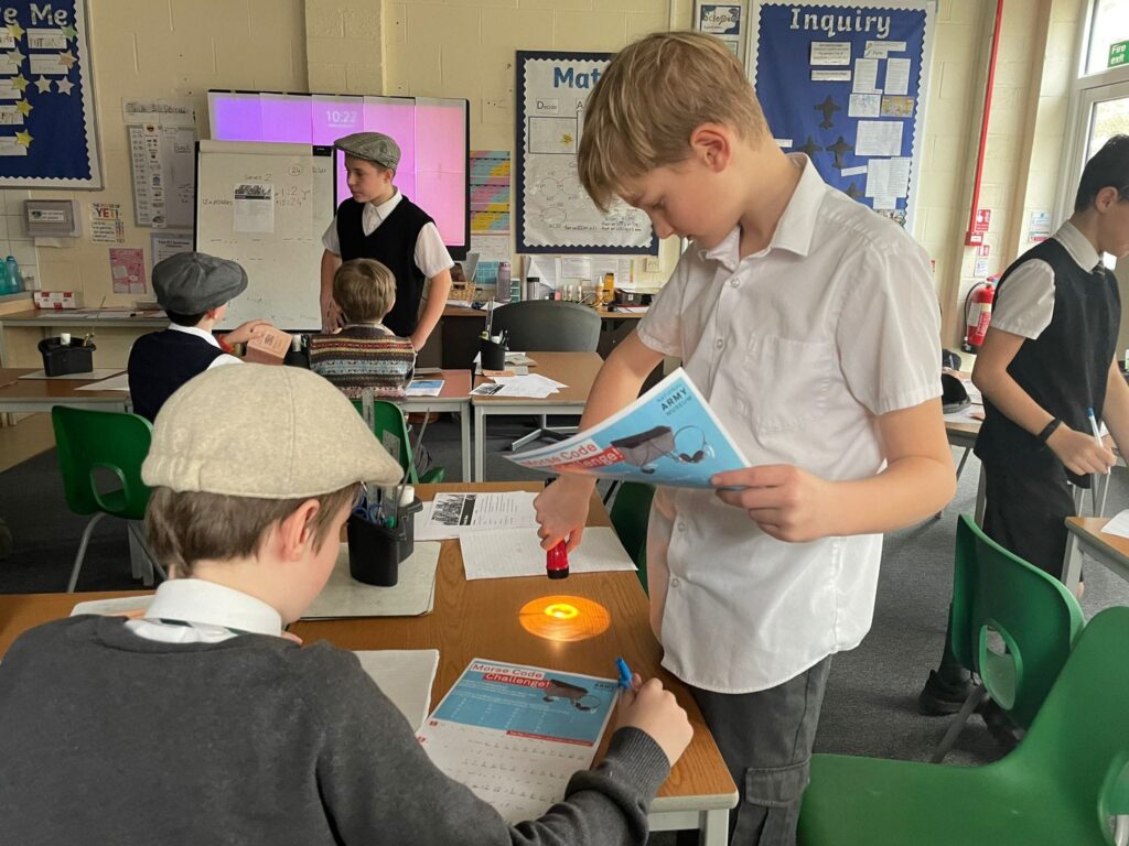 Two male Year 6 students are seen learning about WWII evacuees and interacting with some of the objects they might have used.