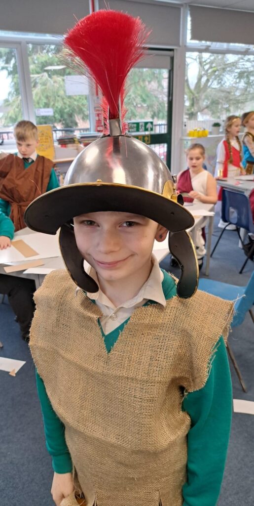 A student smiling for a photo dressed as a Roman