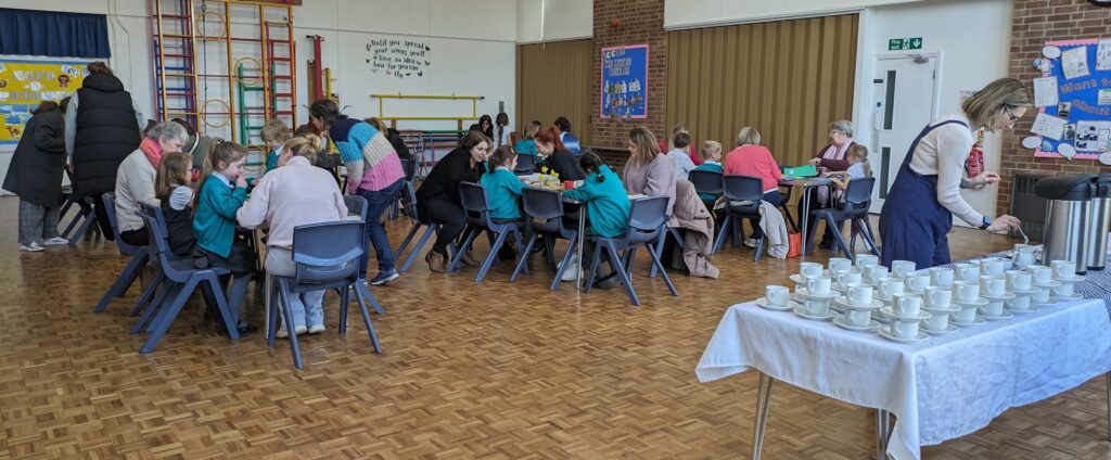 Students are seen sat at tables together with their mothers in the main hall, during a Fabulous Females Afternoon.
