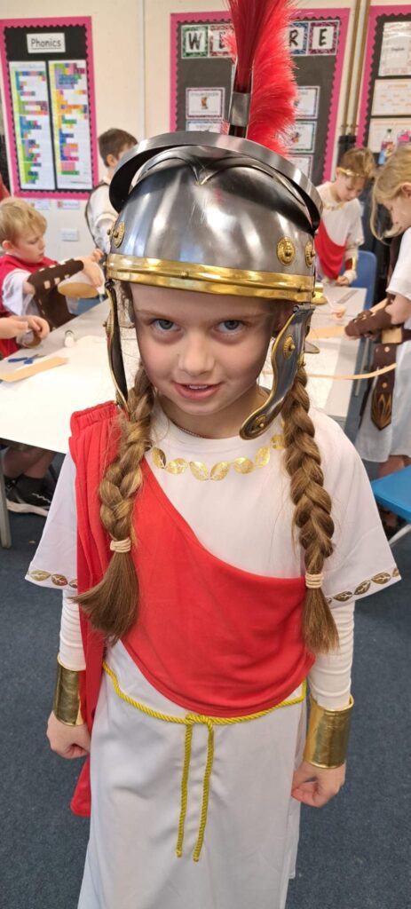 A student smiling for a photo dressed as a Roman