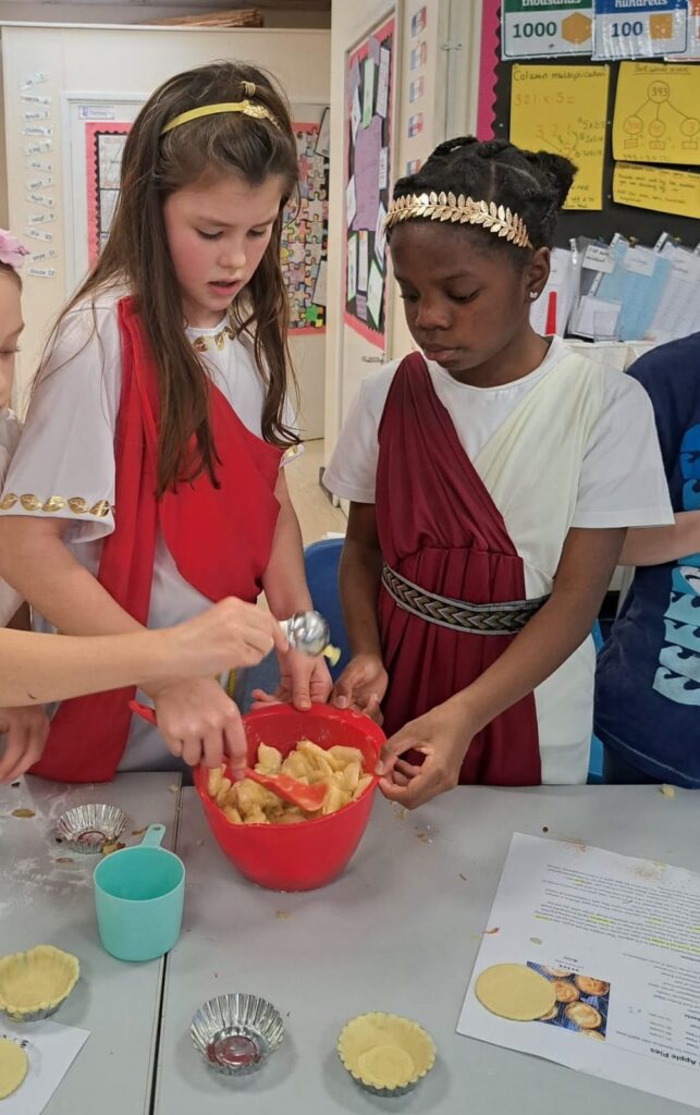 Students dressed as Romans following a recipe