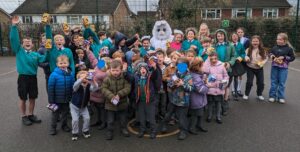 Easter Bunny stood with children posing for the camera on a school playground